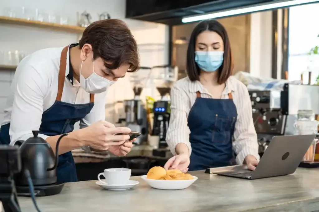 Barista Checking Digital Marketing Analytics On Smartphone To Understand What Cpa Is In Cafe Setting barista checking digital marketing analytics on smartphone to understand what cpa is in café setting.