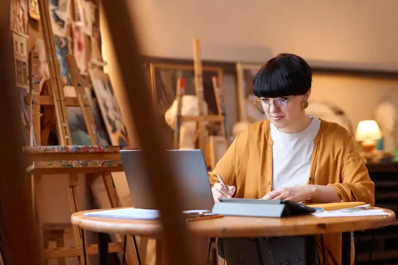 woman using laptop in art studio