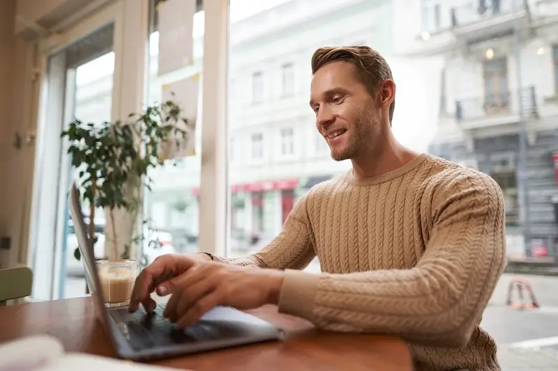 man sitting in cafe with laptop. digital nomad freelancer working